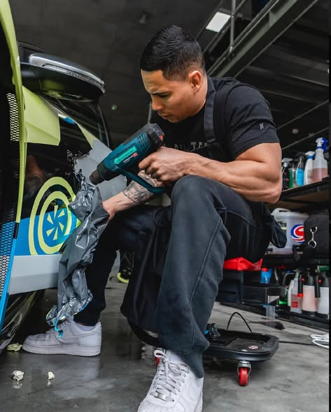 LXT technician applying paint protection film to a dark vehicle